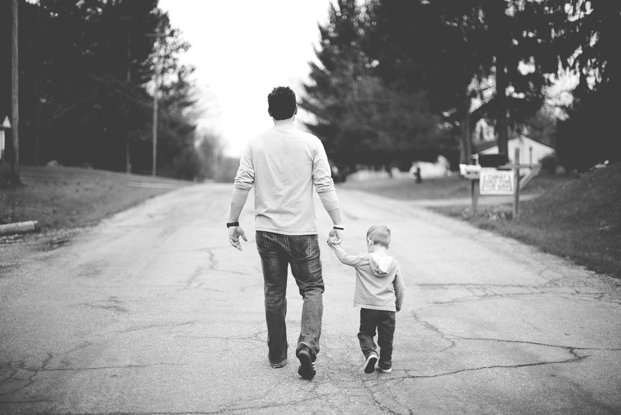 A father and his young son walking hand in hand