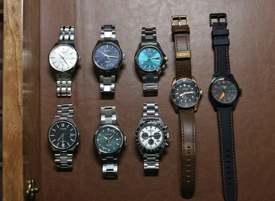 A collection of automatic watches laid out on leather